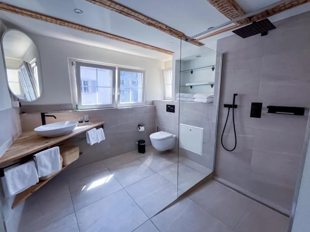 Bathroom with rain shower and glass partition at stattHotel Zurich