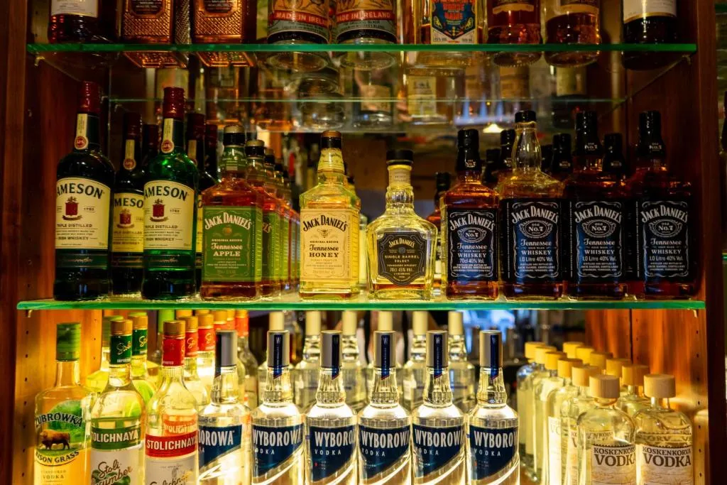 Spirituosen-Auswahl im beleuchteten Regal der stattHotel-Bar