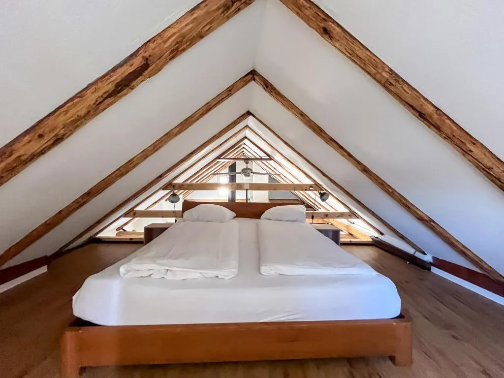 Attic room with exposed wooden beams from 1450 at stattHotel Zurich