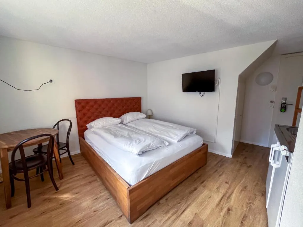 Double room with seating corner and bistro table at stattHotel Zurich
