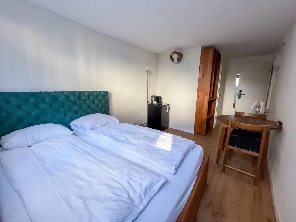 Double room at stattHotel Zurich with large bed and velvet headboard