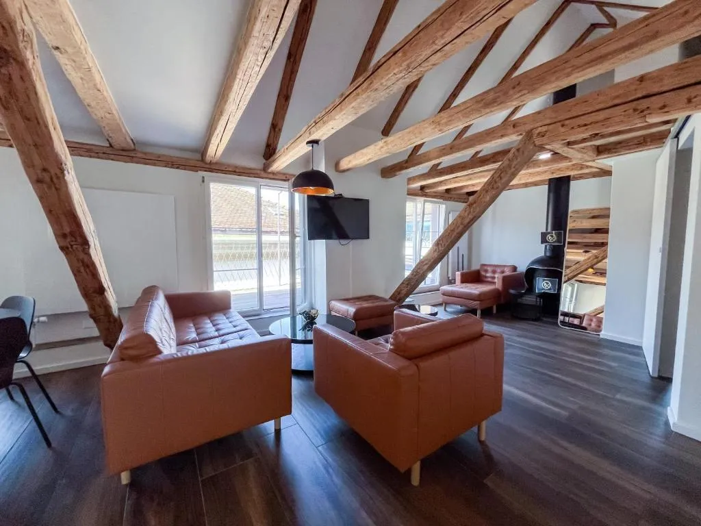 Suite lounge with leather sofas under the historic roof truss