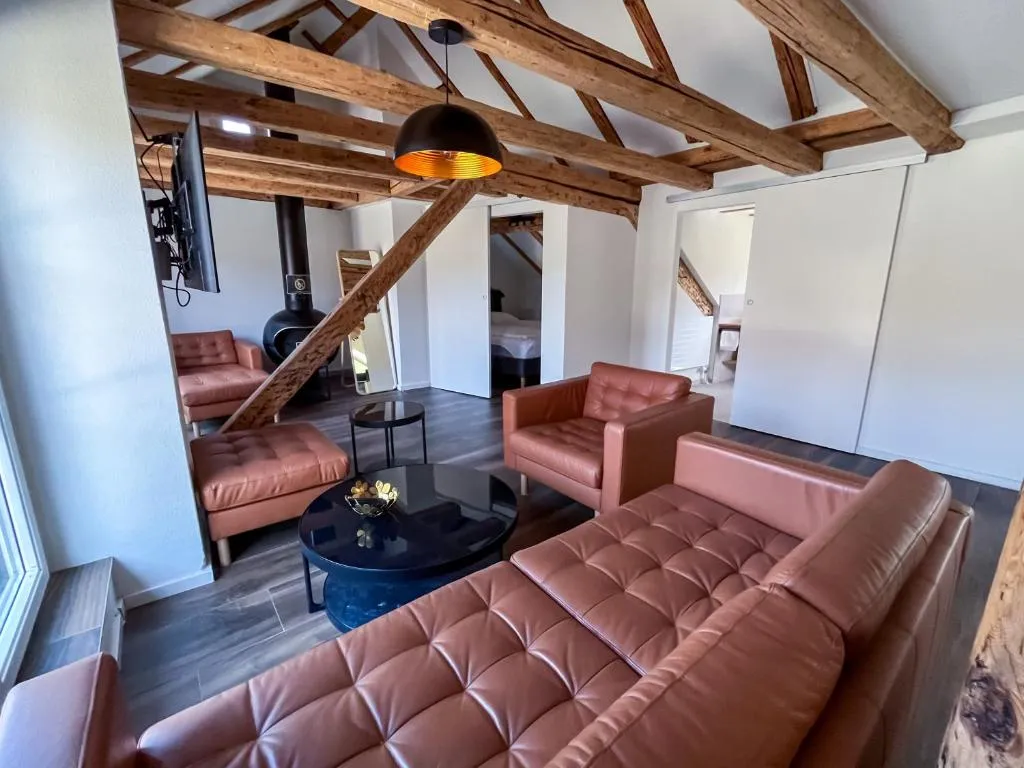 Suite at stattHotel Zurich with leather sofas under historic wooden beams